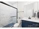 Modern bathroom with a marble tile shower, sleek glass door, and navy blue vanity at 118 Golden Trl, Mooresville, NC 28115