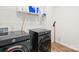 This well-lit laundry room includes a set of washer and dryer with overhead shelving for laundry supplies at 118 Golden Trl, Mooresville, NC 28115