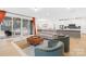Open-plan living room with gray leather couch, chairs, and access to a screened-in porch at 118 Golden Trl, Mooresville, NC 28115
