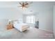 Cozy bedroom featuring a ceiling fan, large window with curtains, and carpeted floors at 11907 Maria Ester Ct, Charlotte, NC 28277