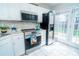Bright kitchen featuring stainless steel appliances, white cabinets, and modern tiled backsplash at 11907 Maria Ester Ct, Charlotte, NC 28277