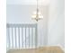 Carpeted stairway and landing area illuminated by an elegant chandelier at 11907 Maria Ester Ct, Charlotte, NC 28277
