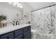 Bathroom featuring a shower with a leaf patterned shower curtain and navy blue cabinets at 125 Round Tuit Ln, Mt Ulla, NC 28125