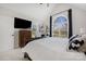 Main bedroom with a ceiling fan, tv, ensuite bathroom, and a large arch window at 125 Round Tuit Ln, Mt Ulla, NC 28125
