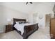 Bright main bedroom with a ceiling fan, neutral carpet, and access to the ensuite bathroom and the stairway at 125 Round Tuit Ln, Mt Ulla, NC 28125