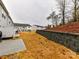Image displaying backyard with retaining wall, concrete patio, lawn, and neighboring homes at 1365 Eagle Claw Dr, Kannapolis, NC 28083