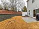 Backyard with a concrete patio, retaining wall, and a view of the side of the house at 1365 Eagle Claw Dr, Kannapolis, NC 28083
