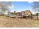 Backyard with a brick home, sunroom and tiered deck area, complemented by a fenced yard at 137 Dellinger Dr, Statesville, NC 28625