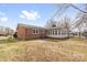 Rear view of a brick home with an attached sunroom, set in a spacious, fenced backyard at 137 Dellinger Dr, Statesville, NC 28625