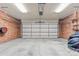 Clean and spacious two-car garage with a brick accent wall, overhead storage and concrete floor at 137 Dellinger Dr, Statesville, NC 28625