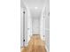 Well-lit hallway with wood-look flooring, white wainscoting, and multiple doorways leading to various rooms at 137 Dellinger Dr, Statesville, NC 28625