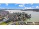 Breathtaking aerial view showcasing waterfront property surrounded by tranquil waters, mature trees and dock at 14021 Queens Harbor Rd, Charlotte, NC 28278
