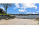 Sandy beach with picnic tables on the lakefront, showcasing community amenities at 14021 Queens Harbor Rd, Charlotte, NC 28278