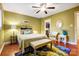 Green bedroom with wood floors, a ceiling fan, and wicker chairs at 14021 Queens Harbor Rd, Charlotte, NC 28278