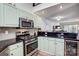 Stylish kitchen boasting stainless steel appliances, black countertops, and light green cabinetry, creating a welcoming culinary space at 14021 Queens Harbor Rd, Charlotte, NC 28278