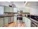 Well-equipped kitchen featuring stainless steel appliances, ample counter space, and stylish sage green cabinetry at 14021 Queens Harbor Rd, Charlotte, NC 28278