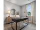 Bright home office featuring a gray carpet, decorative mirror, wooden desk, and modern furnishings at 2022 Mantle Ridge Dr, Indian Trail, NC 28079