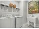 Clean laundry room with modern washer, dryer, sink, and storage at 2022 Mantle Ridge Dr, Indian Trail, NC 28079