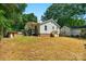 A fenced backyard featuring a grassy area and mature trees providing shade at 233 Proctor St, Gastonia, NC 28052