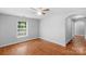 Neutral bedroom showcasing wood-look flooring, a ceiling fan, and a sunlit window at 233 Proctor St, Gastonia, NC 28052