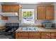 Classic kitchen with wooden cabinets, stainless steel sink, and a view from the window at 233 Proctor St, Gastonia, NC 28052