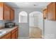 Open-concept kitchen with wood cabinets, laminate countertops, and pass-through to the dining area at 233 Proctor St, Gastonia, NC 28052