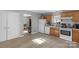 Bright kitchen area with white appliances, wood cabinets, and an open view to living room at 233 Proctor St, Gastonia, NC 28052