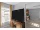 Well-lit living room boasts a large TV, neutral walls, and a view into the adjacent kitchen at 233 Proctor St, Gastonia, NC 28052