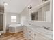 Bathroom featuring a soaking tub, double sinks, and a shower with glass doors at 236 Sailwinds Rd, Mooresville, NC 28115