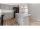 Kitchen featuring gray cabinets, speckled countertops, a black refrigerator, and an island with storage at 236 Sailwinds Rd, Mooresville, NC 28115