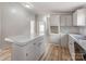 Kitchen featuring white cabinets, tile backsplash, speckled countertops, and an island with storage at 236 Sailwinds Rd, Mooresville, NC 28115