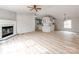 Open-concept living room with fireplace, ceiling fan, and seamless transition to kitchen at 236 Sailwinds Rd, Mooresville, NC 28115