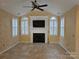 Bright living room featuring a fireplace with built-ins, arched windows, and a ceiling fan at 2656 Polo Club Blvd, Matthews, NC 28105