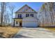 Two-story home with white siding, a two-car garage and a concrete driveway set against a backdrop of trees at 268 Lytton Farm Rd, Troutman, NC 28166