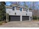 Three-car garage with a painted brick exterior and well-maintained landscaping at 3212 Lazy Branch Rd, Charlotte, NC 28270