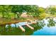 Aerial view of a private dock on a calm lake, lined with lush greenery and mature trees at 324 Bridgewater Ln, Mooresville, NC 28117