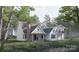 Beautiful modern home with back porch, a brick chimney, and views of the surrounding lush landscape at 324 Bridgewater Ln, Mooresville, NC 28117