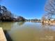 Picturesque lake view showcasing calm waters and beautiful homes in the distance, offering a serene and relaxing atmosphere at 324 Bridgewater Ln, Mooresville, NC 28117