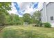 This backyard features lush green grass, a shed, a covered patio, and a wooden fence at 3929 Wexford Ln, Denver, NC 28037