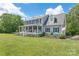 Well-maintained home features a covered porch, manicured lawn, mature trees, and an American flag for classic curb appeal at 3929 Wexford Ln, Denver, NC 28037