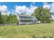 Two-story home boasts a covered porch, spacious lawn, mature trees, and a white fence for added curb appeal on a sunny day at 3929 Wexford Ln, Denver, NC 28037