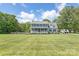 Two-story home features a covered porch, lush lawn, mature trees, and a white fence for added curb appeal on a sunny day at 3929 Wexford Ln, Denver, NC 28037
