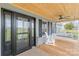Charming front porch featuring a wood ceiling, comfortable seating, and stylish glass front door at 3929 Wexford Ln, Denver, NC 28037