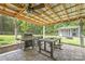 Covered outdoor living space with grill, dining table, a fire pit, and seating area to enjoy outdoor dining with friends at 3929 Wexford Ln, Denver, NC 28037