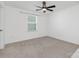 Minimalist bedroom with neutral carpet, white walls, and a modern ceiling fan at 4253 Spadefoot Ct, Lancaster, SC 29720
