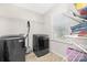Bright laundry room featuring a washer, dryer, storage shelves, and a sunlit window at 4253 Spadefoot Ct, Lancaster, SC 29720