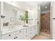 Bright bathroom with double vanity, white cabinets, framed mirrors and a glass enclosed shower at 572 N Church St, Charlotte, NC 28202