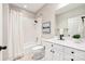 Well-lit bathroom with a shower-tub combo, a vanity with dark hardware, and a decorative framed print on the wall at 572 N Church St, Charlotte, NC 28202