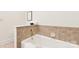 Bathtub with white tiling, gold faucet and fixtures at 572 N Church St, Charlotte, NC 28202
