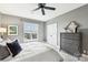 Comfortable bedroom features a dresser with a mirror, a plush bed, and a bright window overlooking the neighborhood at 572 N Church St, Charlotte, NC 28202